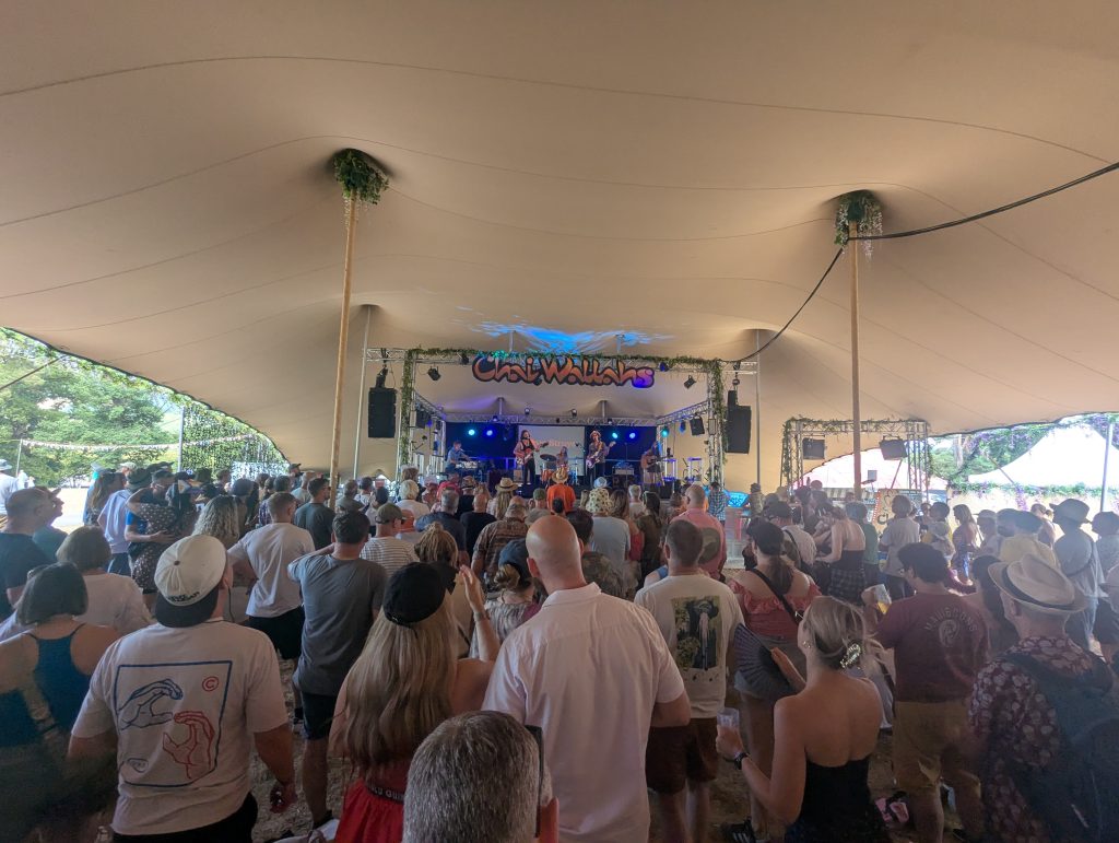 The band playing the Chai Wallahs stage under a big festival tent, watched by a standing crowd
